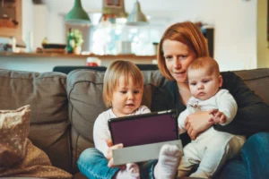 a mother with two children holding a tablet