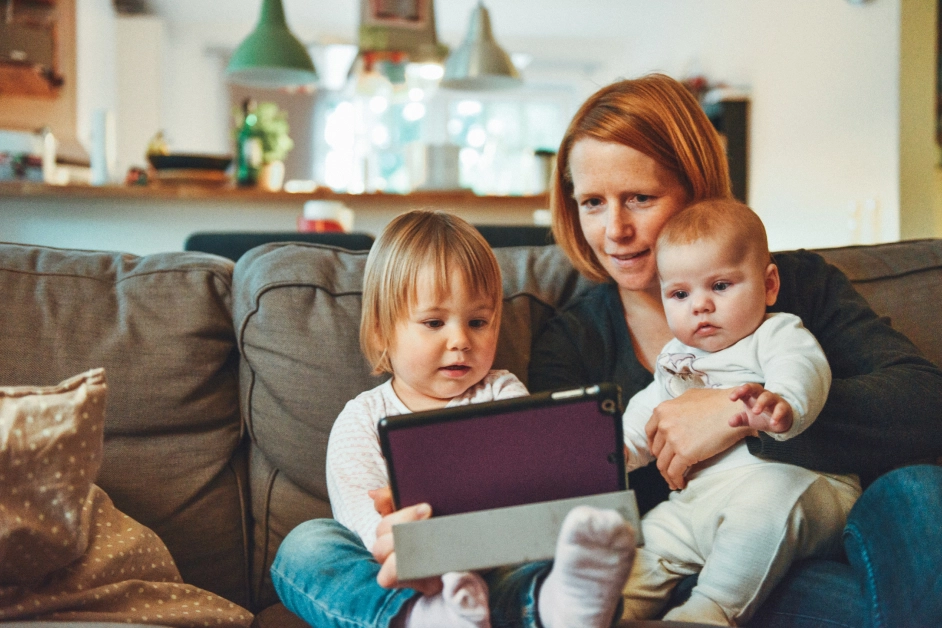 a mother with two children holding a tablet