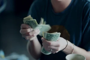a person holding cash and counting it
