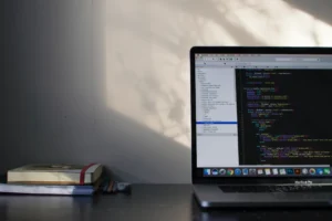 laptop on a desk next to books