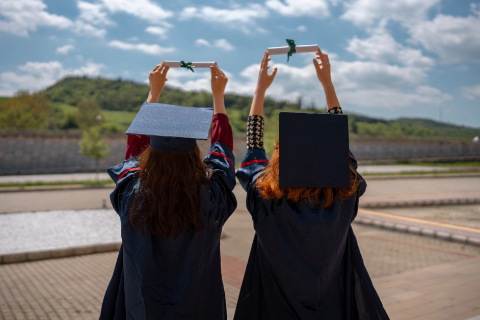 two people wearing graduation gowns