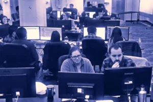several people working on computers right next to each other