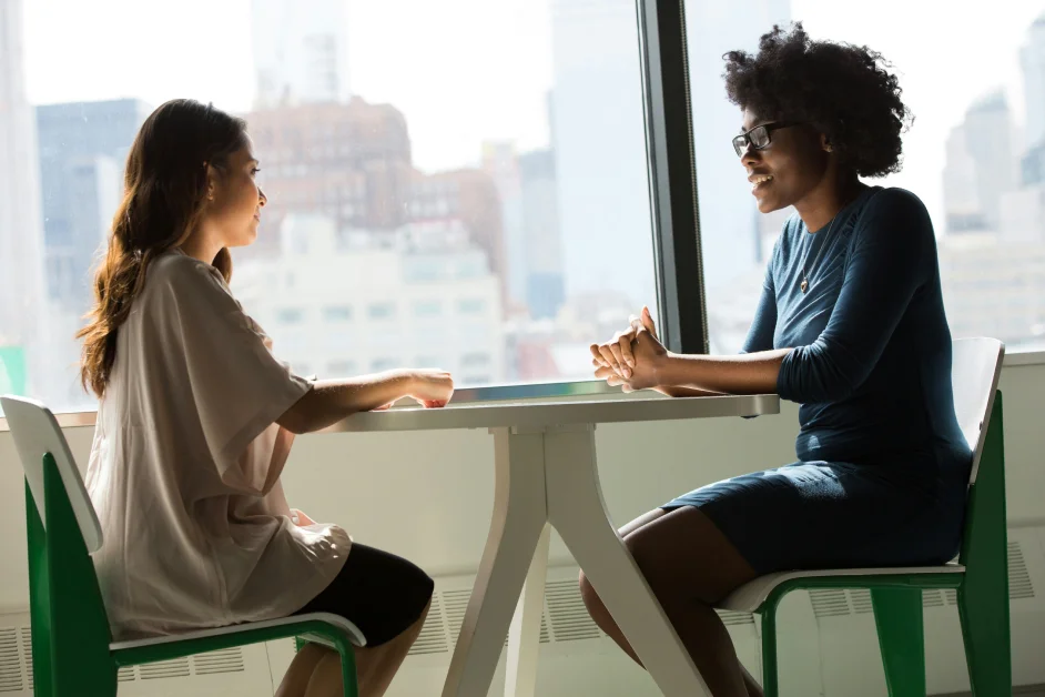 two women sitting at a desk talking