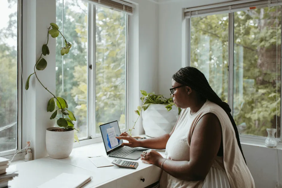 woman working from home on laptop in front of window