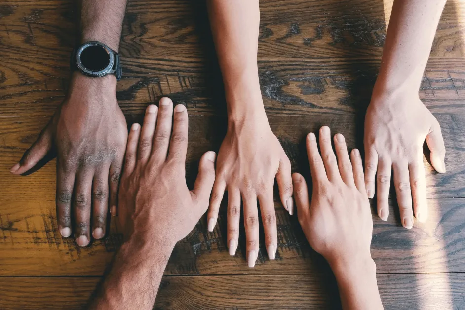 group hands on table